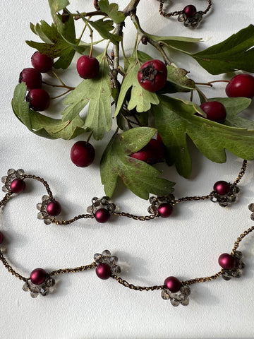 Collana lunga senza chiusura, con perle di vetro color vino e cristalli. Un gioiello elegante che avvolge il collo con stile e raffinatezza naturale